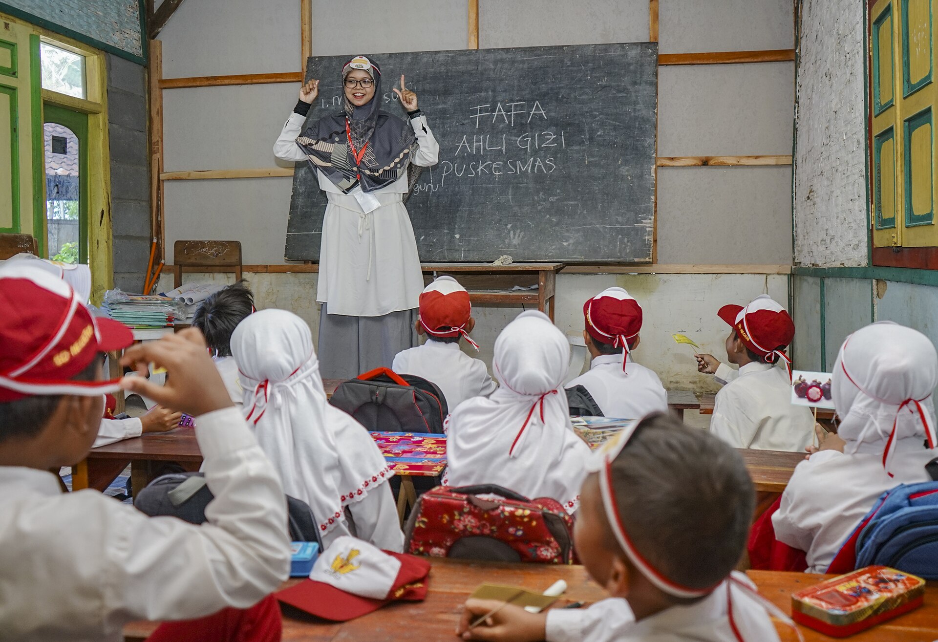 Tenaga pendidik mengajar murid-murid di ruang kelas daerah pedesaan terpencil